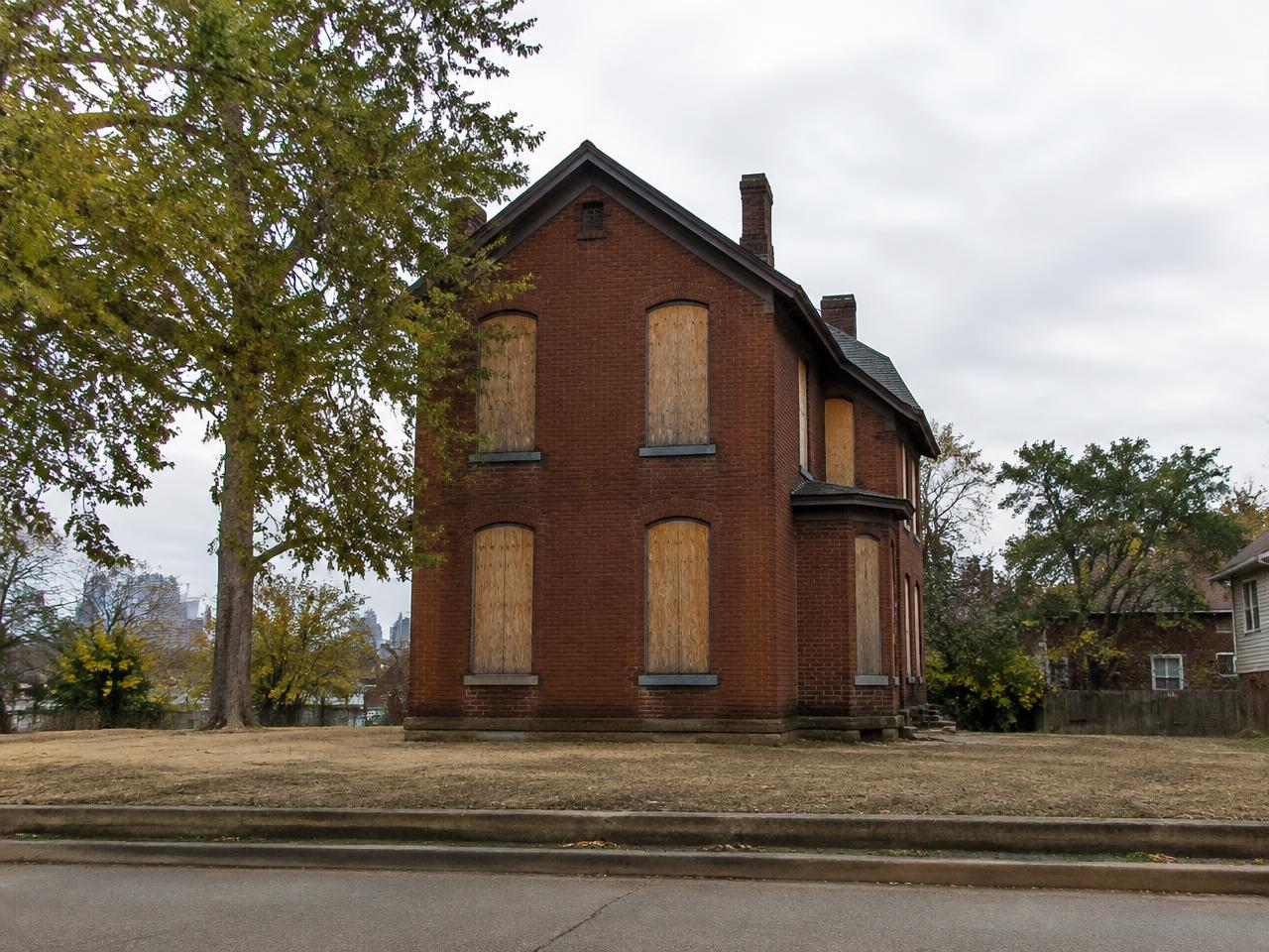 Illustrative photo: a boarded vacant brick house